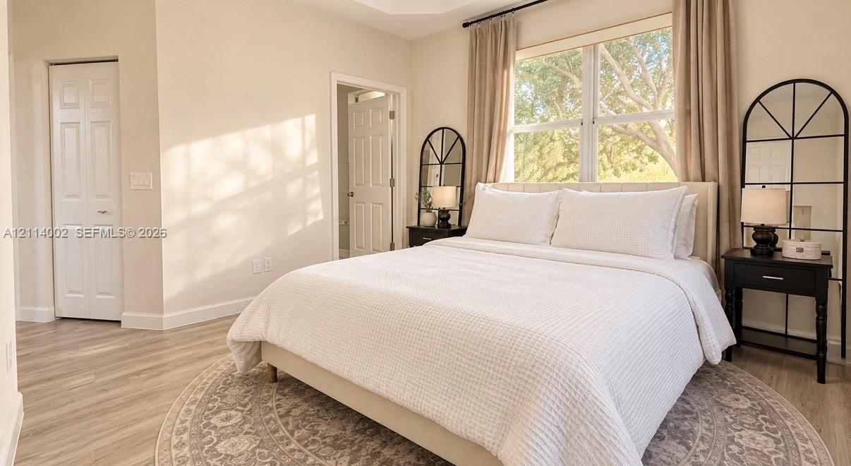 Tray ceiling, wood-finish flooring, and large window with natural light
