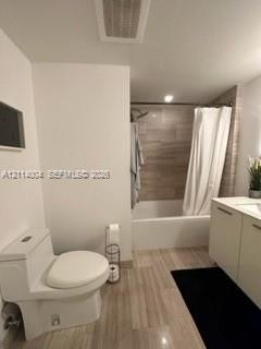 Bathroom featuring a vanity with integrated sink, porcelain tile flooring, and a shower-tub combination with horizontal wall tiling
