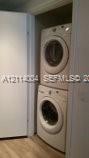 Stacked white laundry unit housed in a dedicated closet