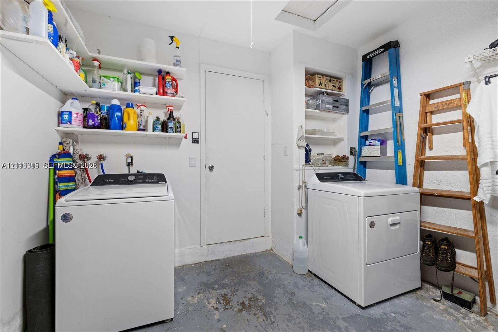 Laundry room featuring built-in open wall shelving and recessed niche storage