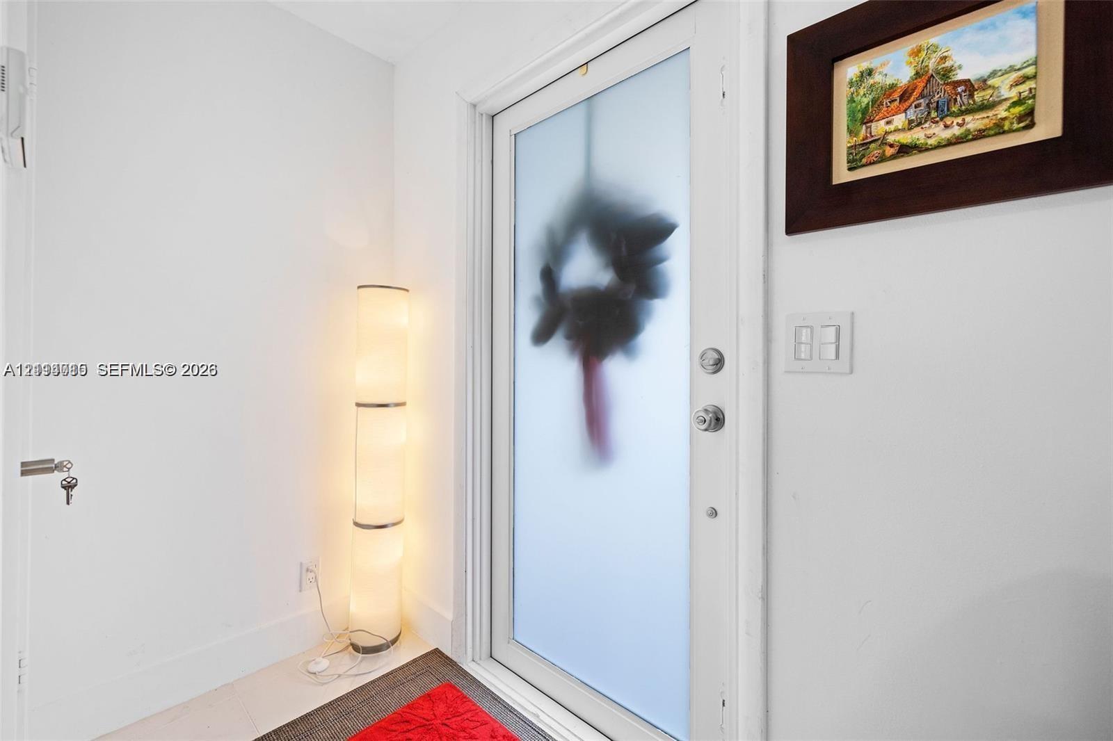 Entry door featuring a white finish, frosted glass panel, and polished metal hardware