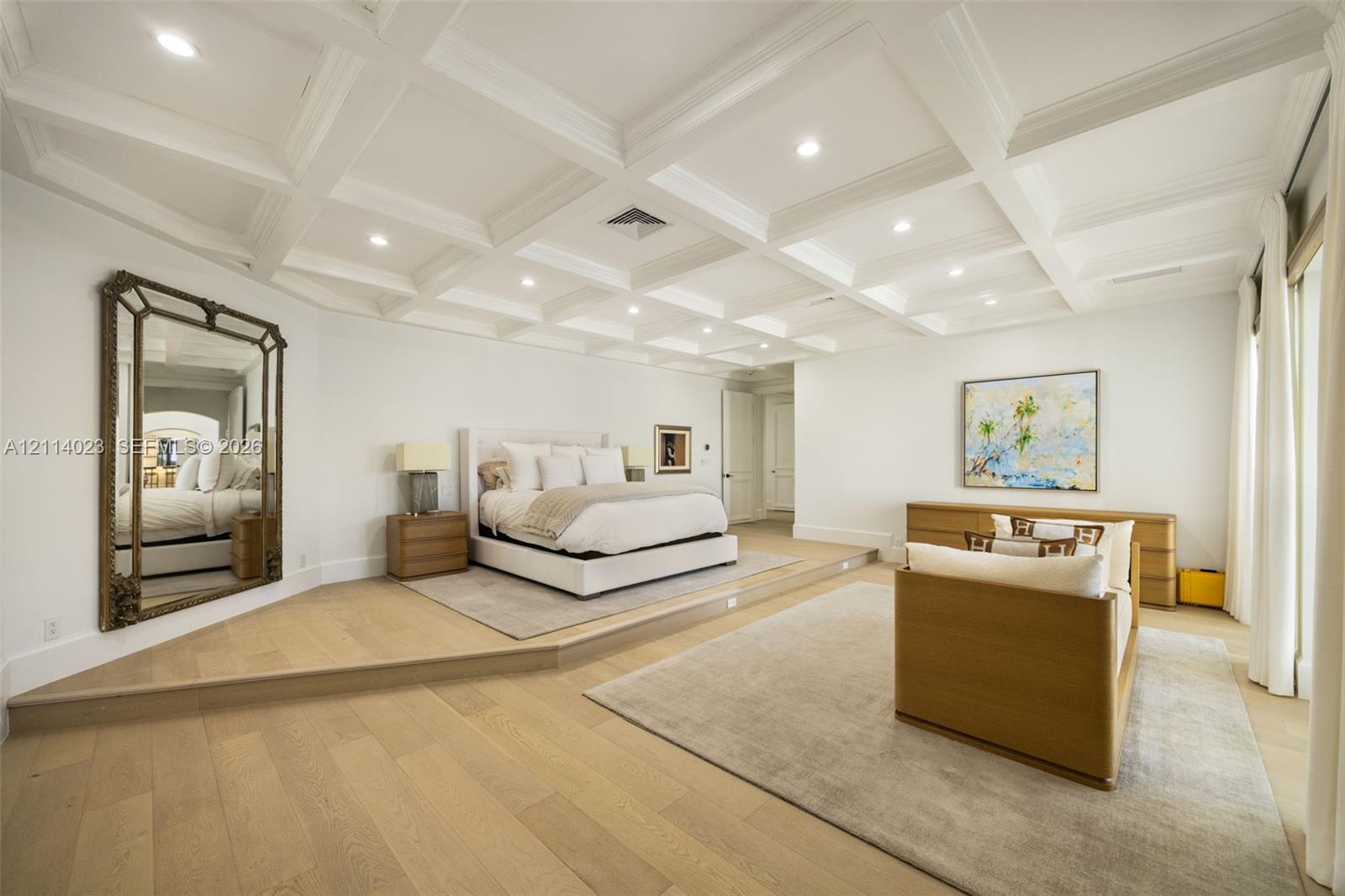 Coffered ceiling with recessed lighting, wood-finish flooring, and a raised platform floor section