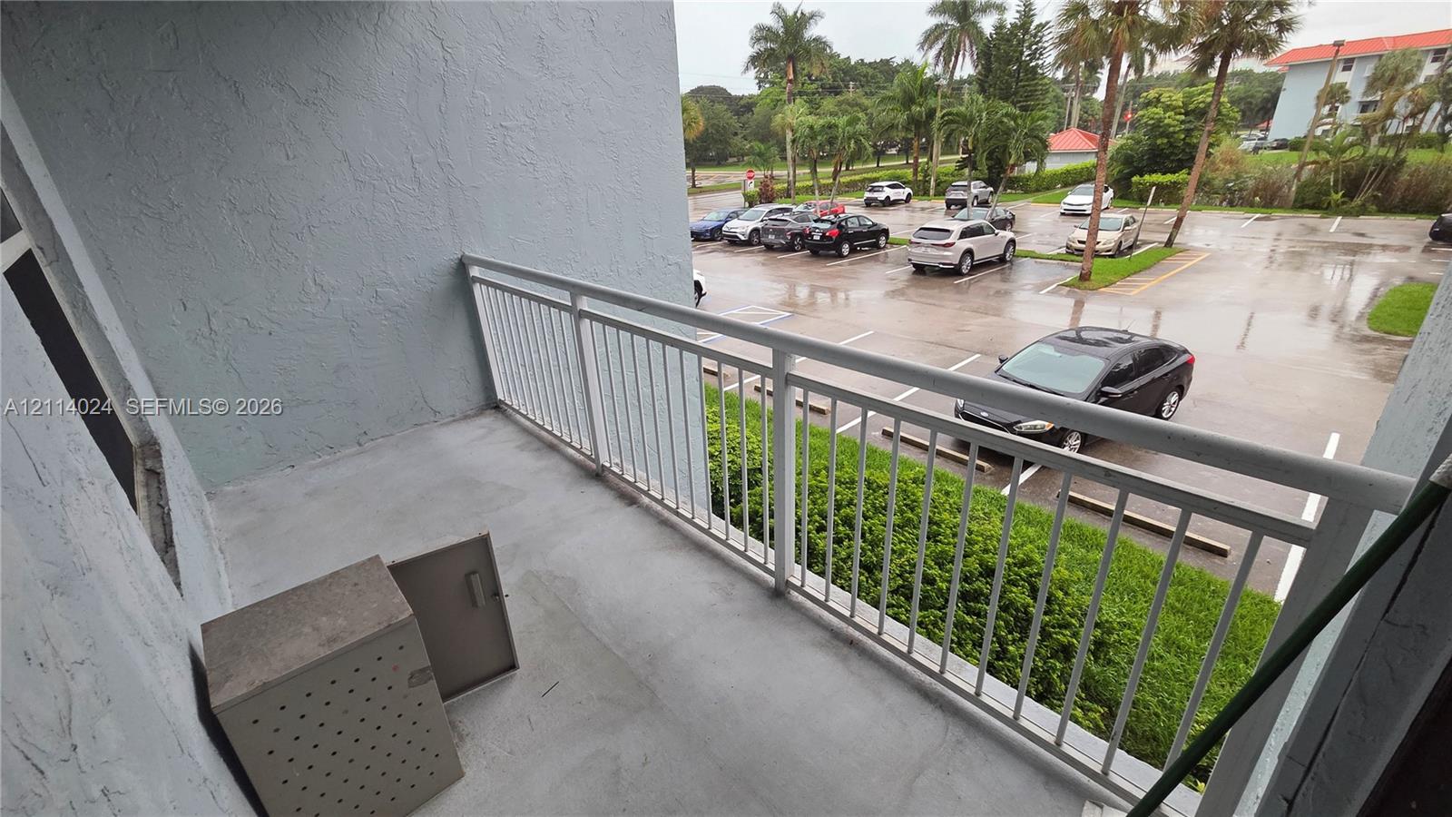 Private balcony featuring concrete flooring, a metal railing, and an integrated exterior storage closet Private balcony featuring concrete flooring, a metal railing, and an integrated exterior storage closet