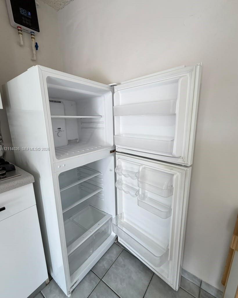 Top-mount white refrigerator featuring adjustable interior shelving, door storage compartments, and crisper drawers