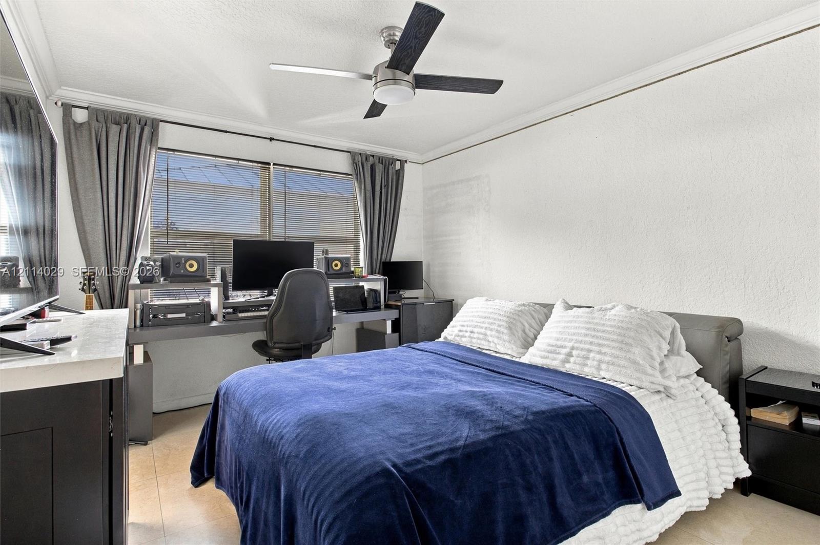 Room featuring a ceiling fan with integrated lighting, large windows, crown molding, and tile flooring