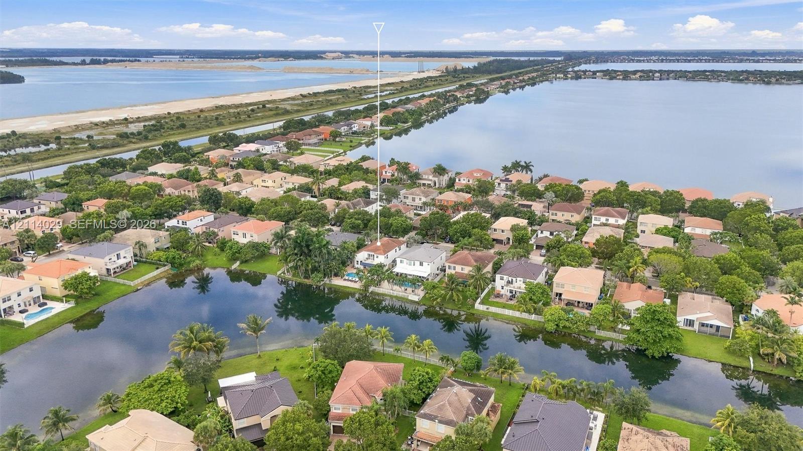 Aerial perspective featuring waterfront placement, private swimming pool, concrete tile roofing, and extensive surrounding water bodies