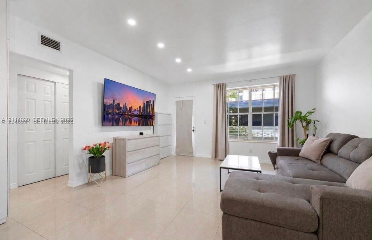 Neutral-toned tile flooring, recessed ceiling lighting, and multi-pane window