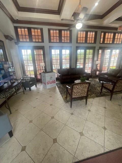 High-ceiling interior featuring tiled flooring with decorative insets, coffered ceiling detail, numerous tall paneled glass doors, and dark wood-finish trim