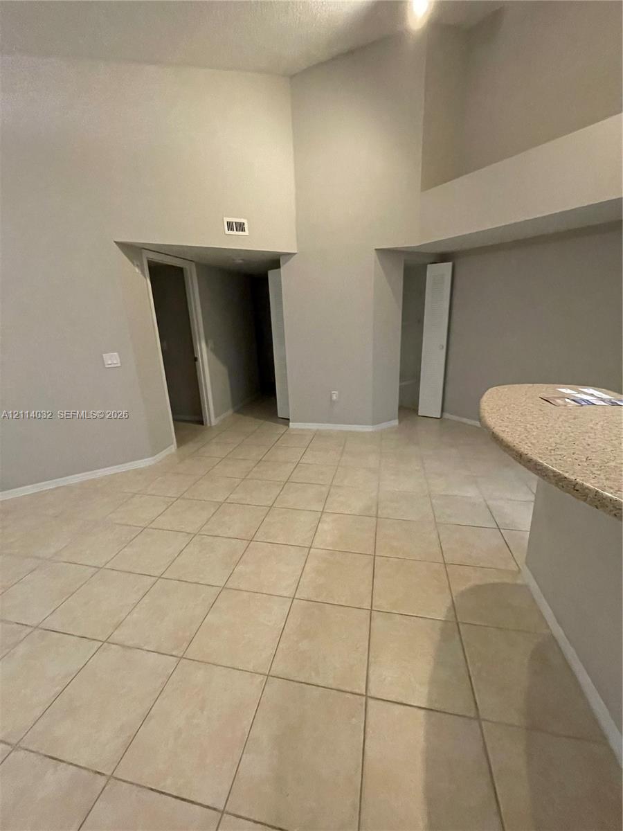Vaulted ceiling featuring tile flooring and a built-in stone-finish countertop