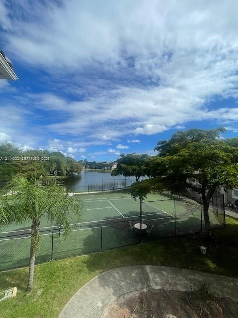Fenced tennis court, water frontage, and mature trees situated on the property grounds