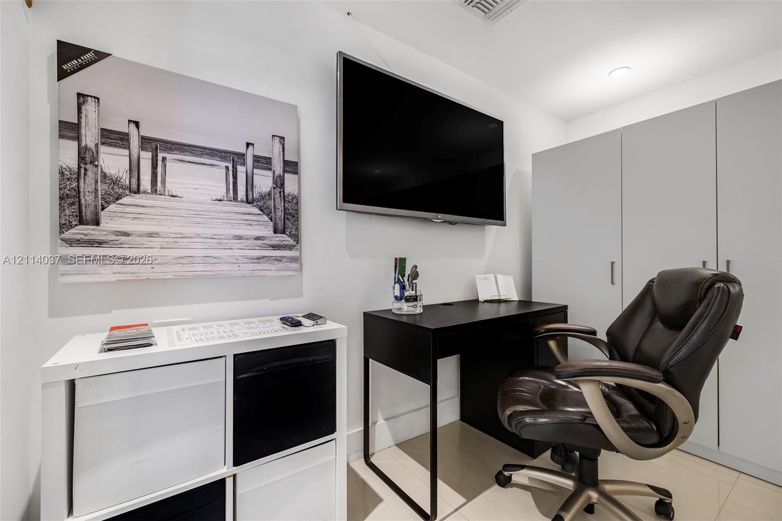 Built-in full-height storage cabinetry, recessed lighting, and tile flooring