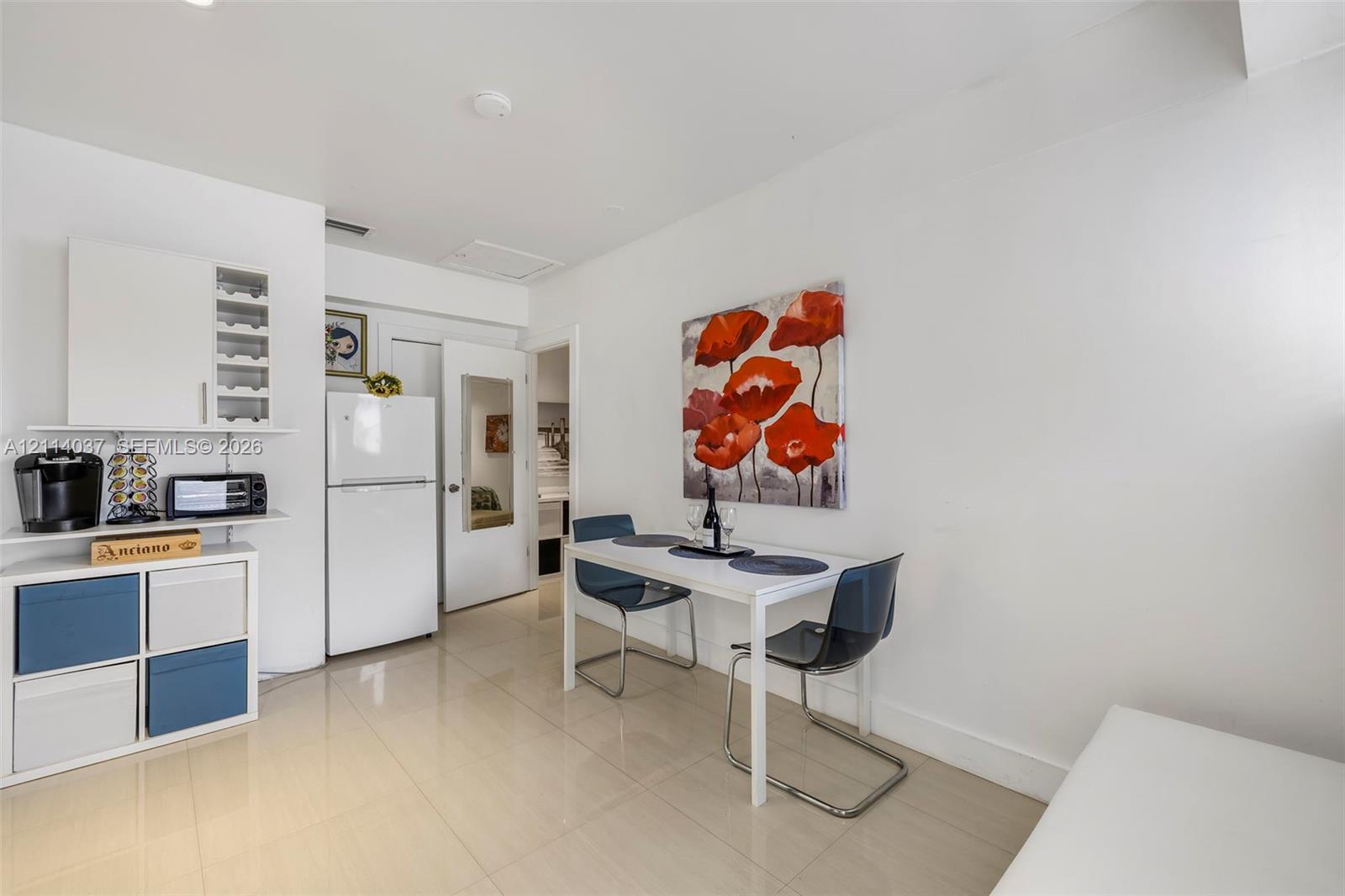 Kitchen area featuring white cabinetry, integrated wine storage, and neutral-toned tile flooring