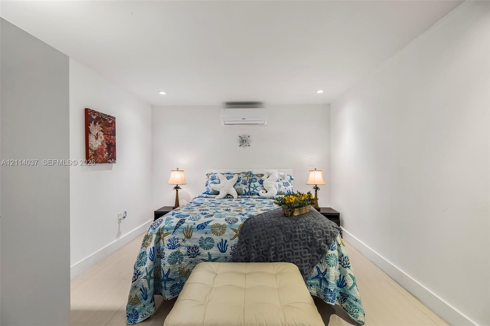 Neutral interior featuring light-toned flooring, recessed lighting, and a wall-mounted ductless climate control unit