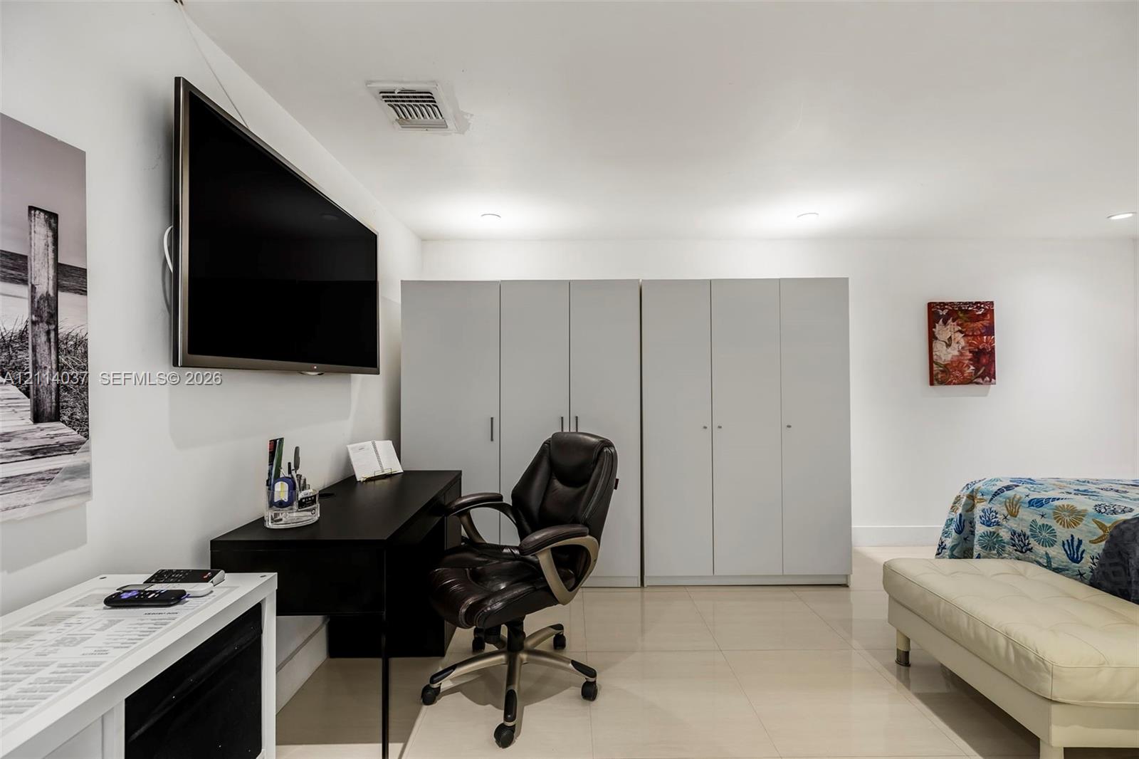 Built-in floor-to-ceiling cabinetry, recessed lighting, and large-format tile flooring