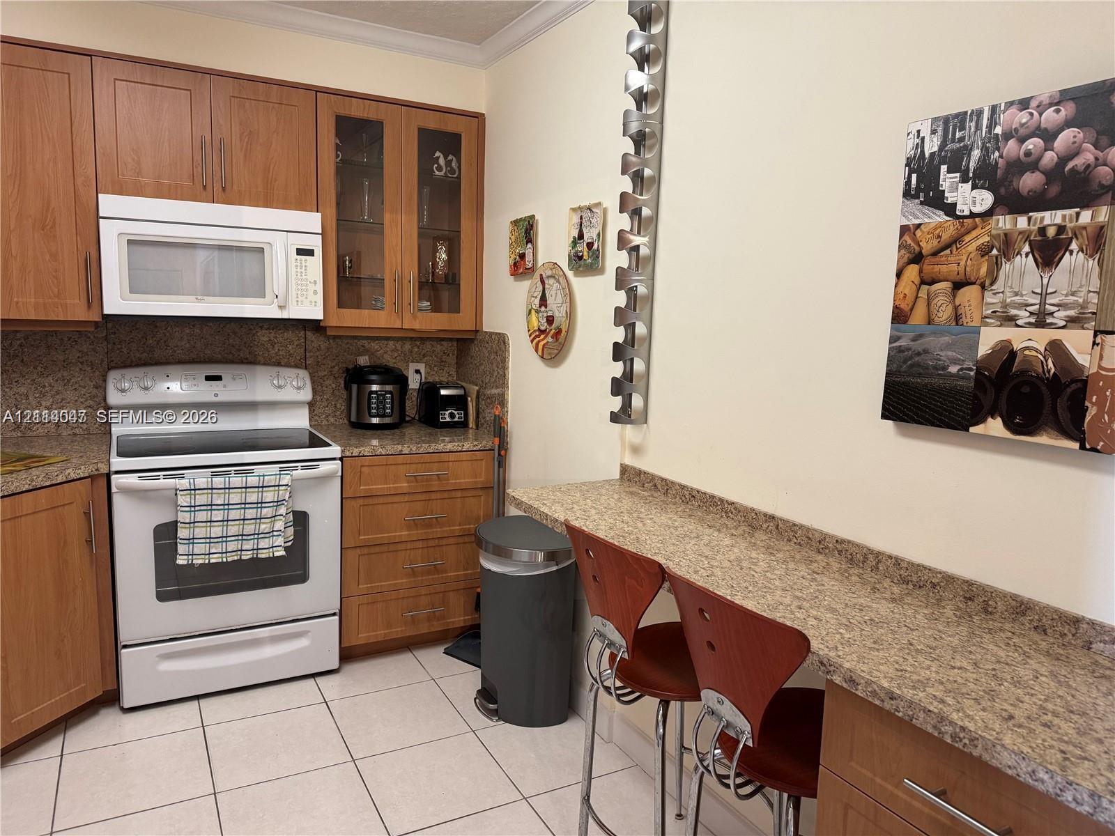 Kitchen featuring wood cabinetry, integrated wine storage rack, built-in microwave, range oven, and extended stone-finish countertop