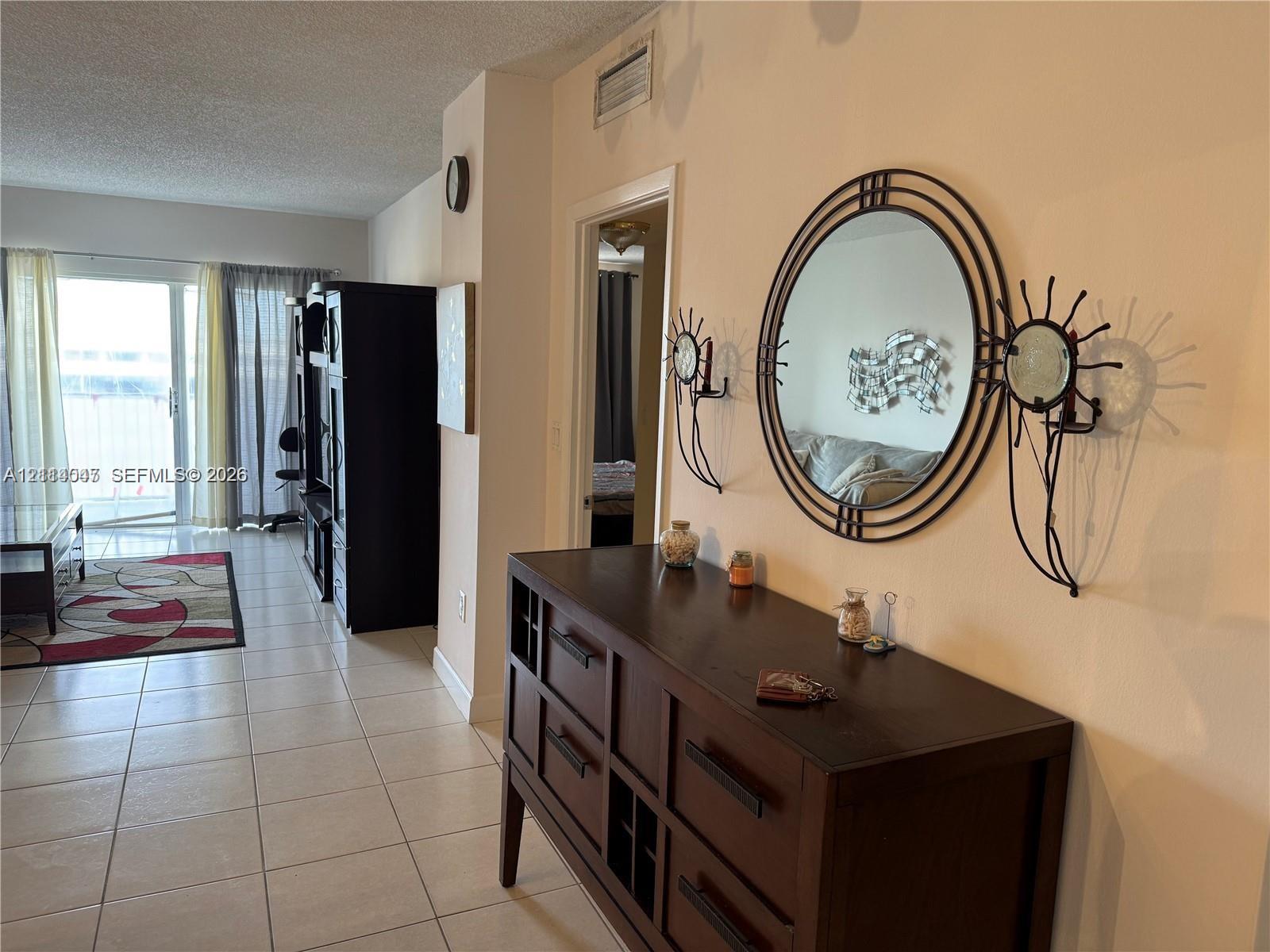 Neutral ceramic floor tiling and sliding glass doors featuring exterior access