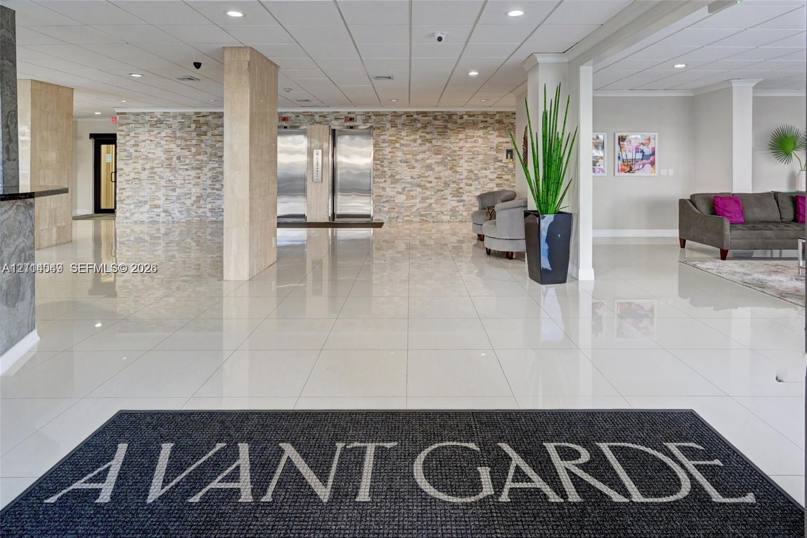 Lobby featuring polished tile flooring, stacked stone wall accents, brushed metal elevator doors, and recessed ceiling lighting Lobby featuring polished tile flooring, stacked stone wall accents, brushed metal elevator doors, and recessed ceiling lighting
