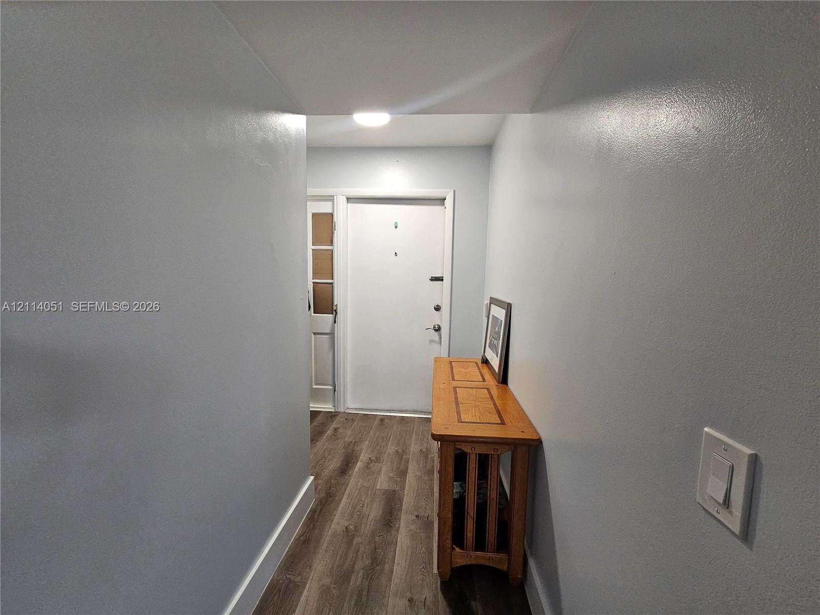 Entry area featuring wood-finish flooring, smooth-finish neutral wall paint, recessed ceiling lighting, and a multi-lite exterior entry door