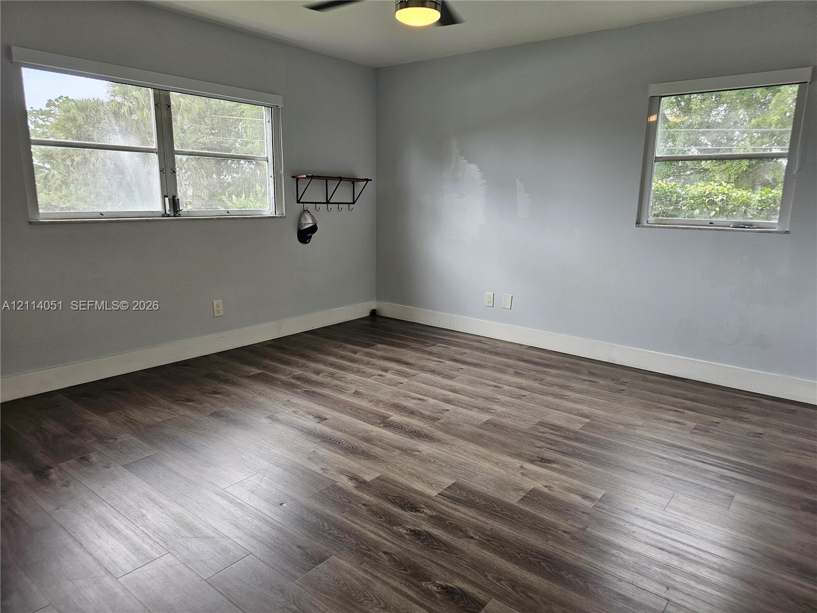 Wood-finish flooring, neutral wall tones, multi-pane windows, and a ceiling-mounted light fixture