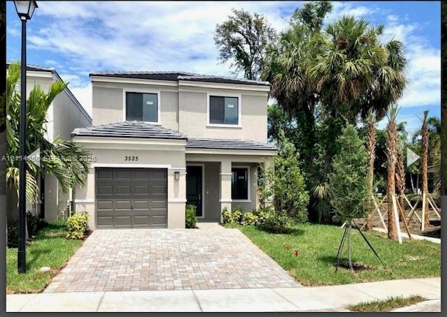 Two-story exterior featuring a neutral stucco facade, tile roofing, an attached single-car garage, and a paved brick driveway Two-story exterior featuring a neutral stucco facade, tile roofing, an attached single-car garage, and a paved brick driveway