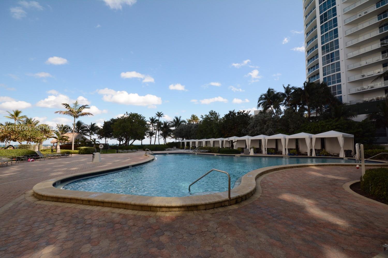 Swimming pool with paved surround, integrated sun loungers, and multiple cabanas Swimming pool with paved surround, integrated sun loungers, and multiple cabanas