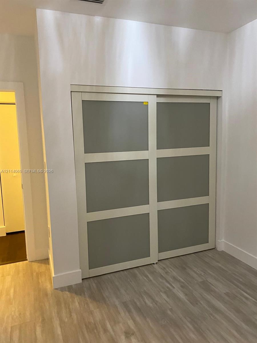 Sliding bypass doors featuring frosted glass panels with white trim and wood-finish flooring