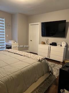 Interior room featuring wood-finish flooring, neutral wall tones, and layered window treatments