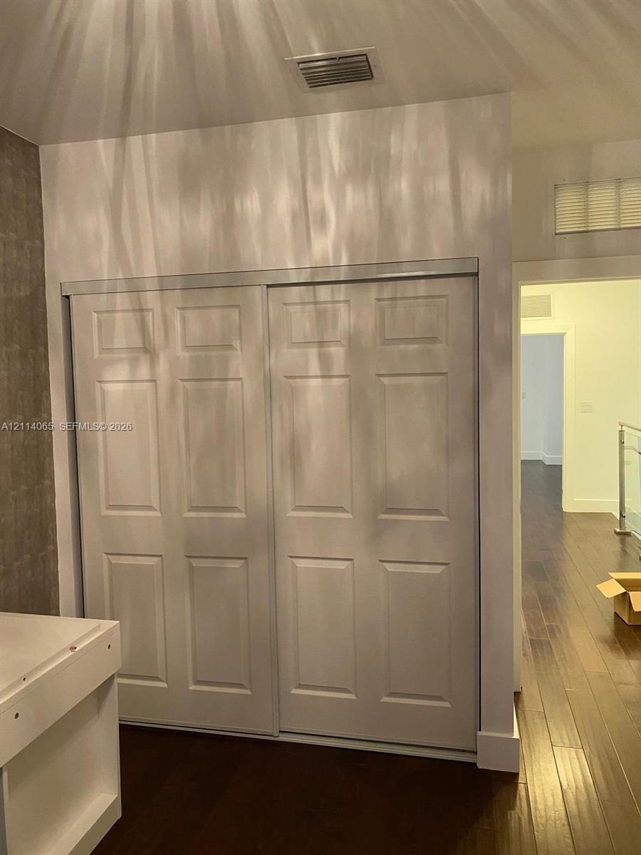 Six-panel sliding closet doors and wood-finish flooring