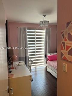 Wood-finish flooring, dual-layered roller shades, and a decorative drum-style ceiling light fixture