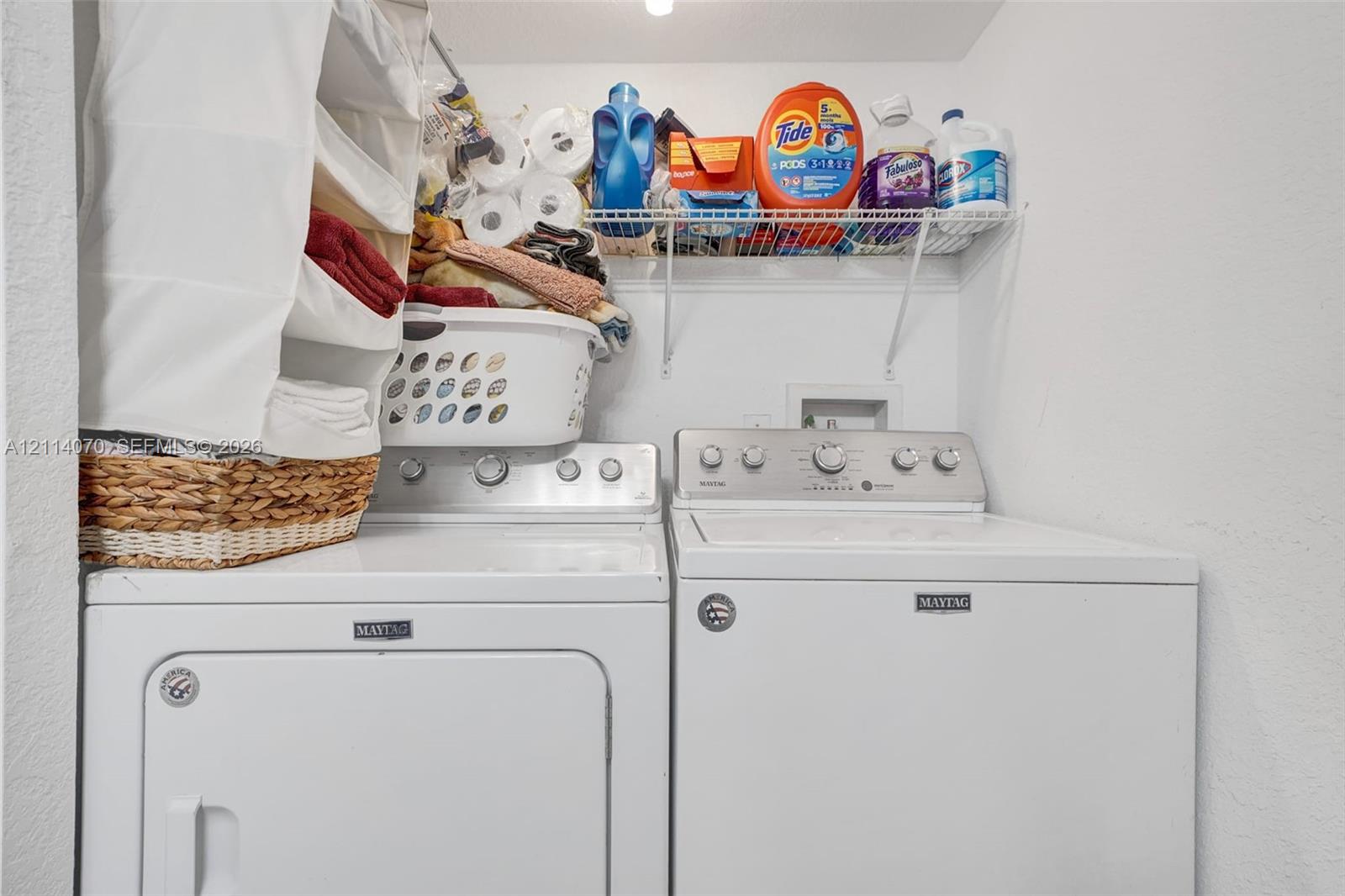 Laundry alcove featuring white appliance hookups and wire shelving