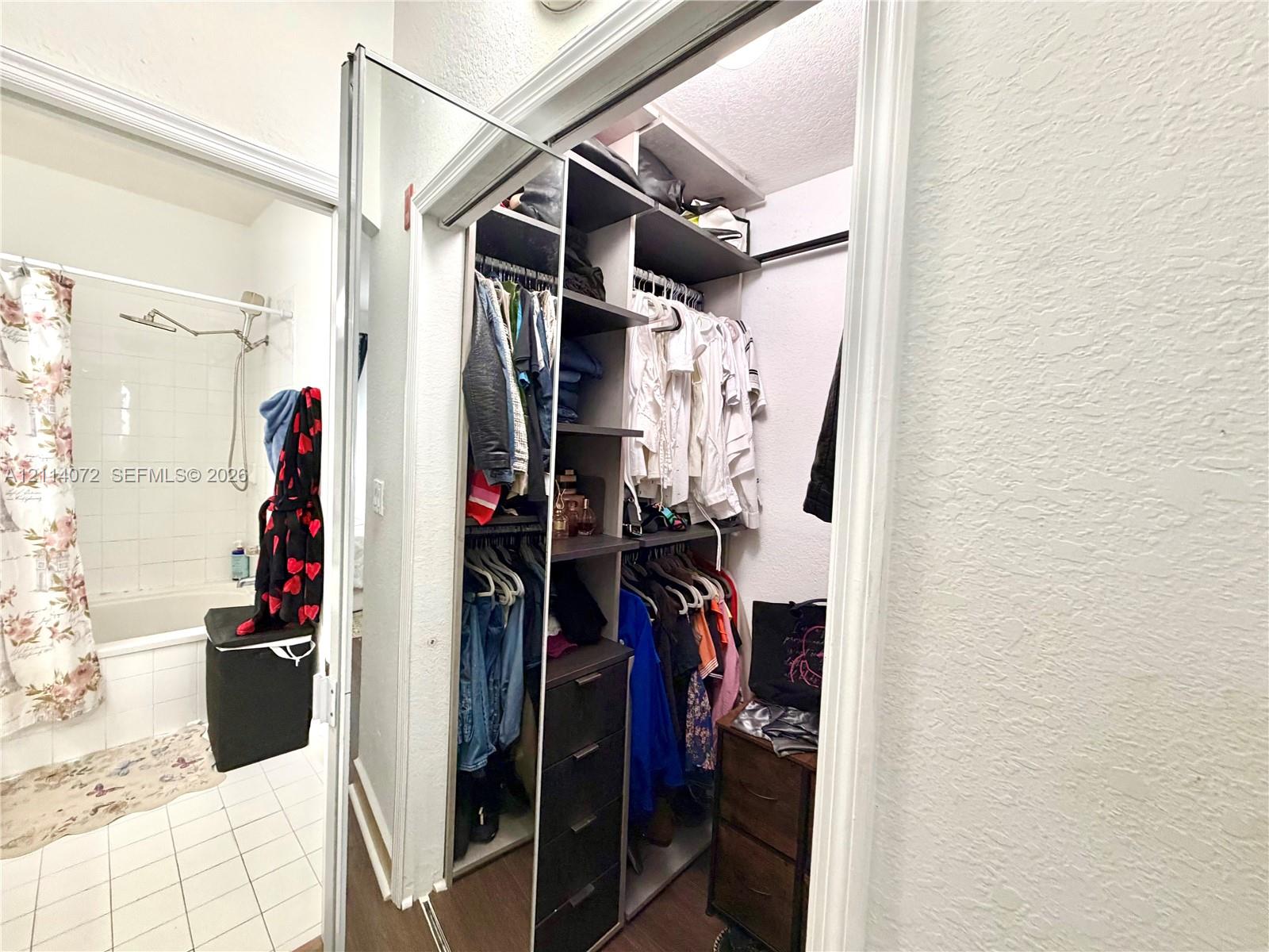 Built-in walk-in closet featuring multi-tiered shelving, hanging rods, and integrated drawer storage