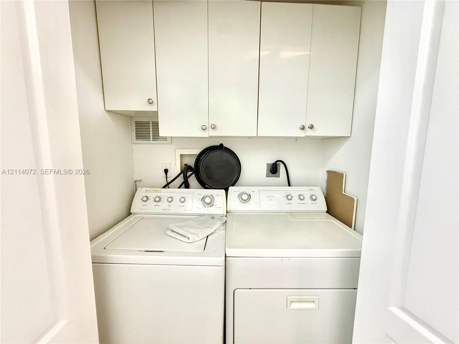 Laundry area featuring white flat-panel upper cabinetry and recessed hookups