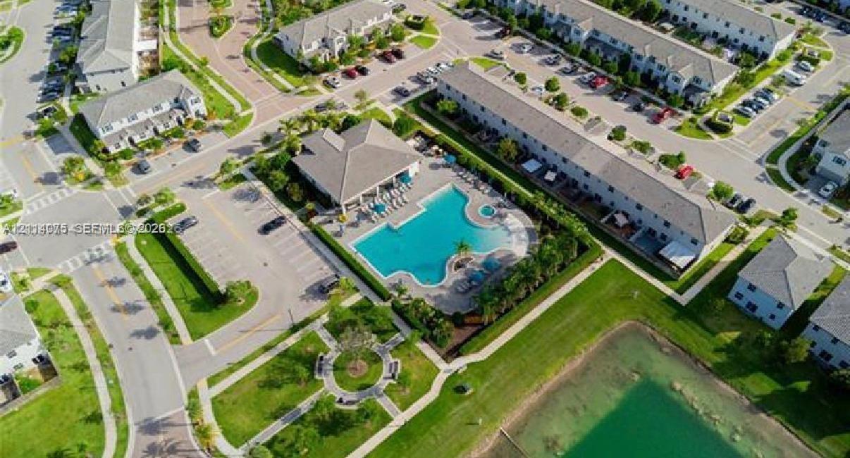 Community recreational facility featuring a swimming pool, integrated spa, covered pavilion, and surrounding landscaped grounds