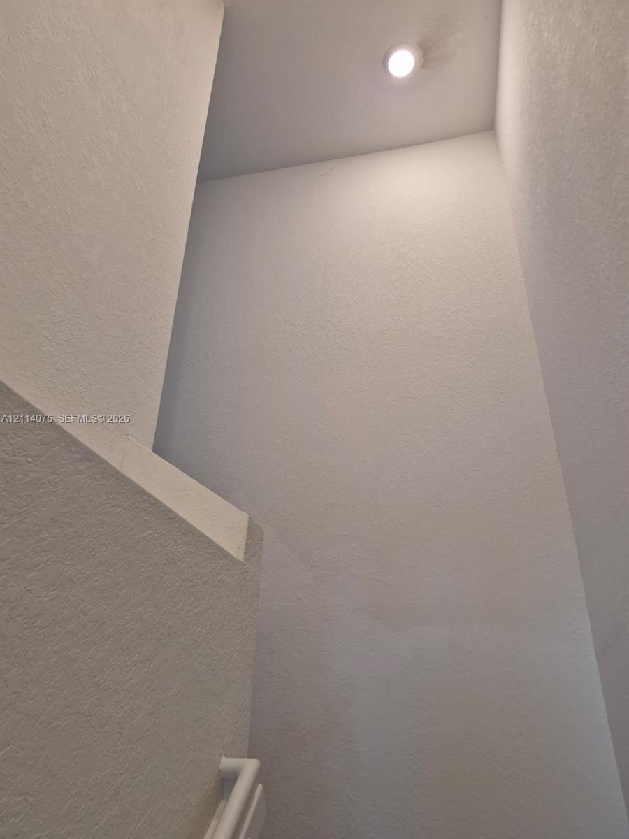 High-reaching wall surfaces, inset ceiling lighting, and a white-finish handrail