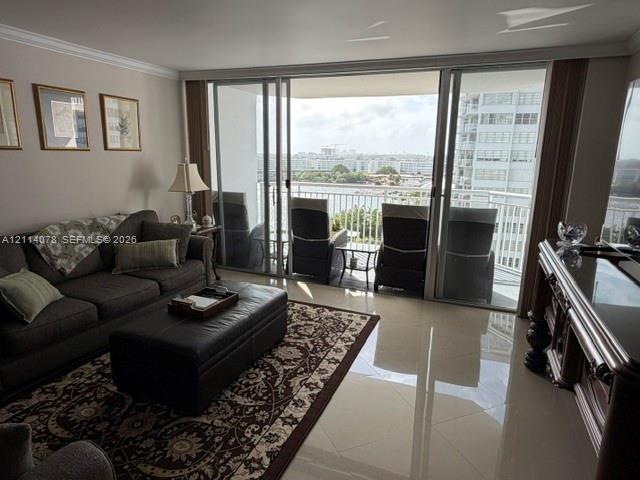 Large sliding glass doors opening to a covered balcony, polished tile flooring, and crown molding
