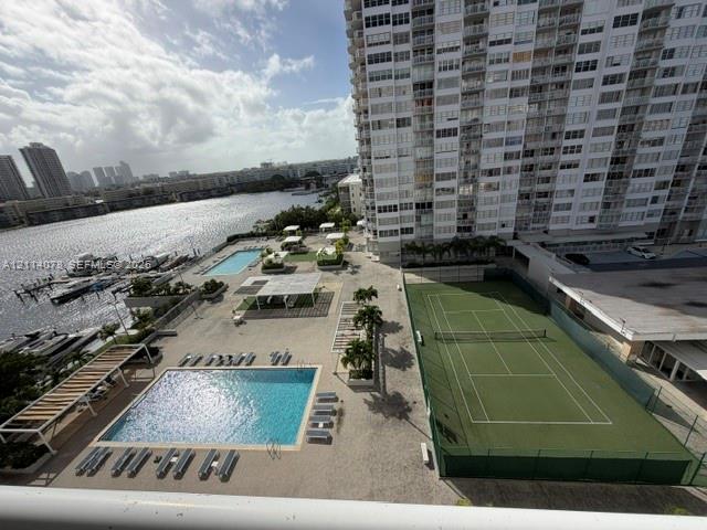 Outdoor amenities featuring multiple swimming pools, a tennis court, shaded seating structures, and a private dock area