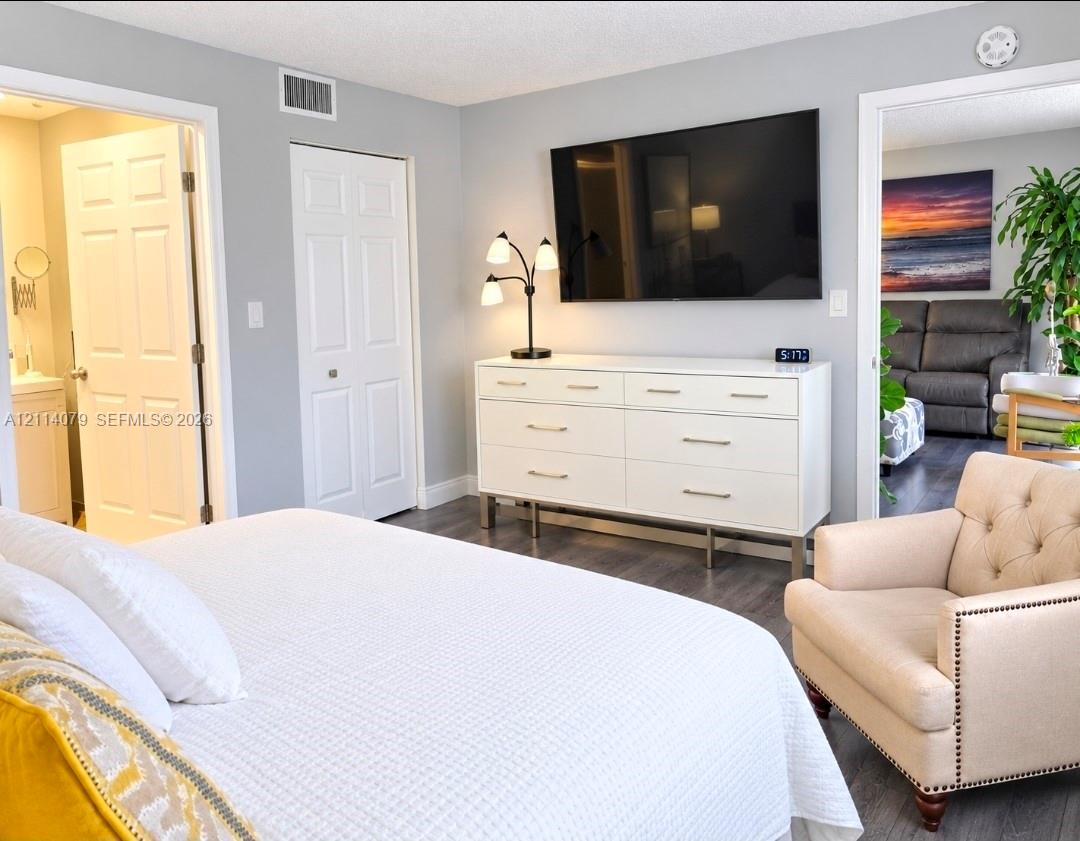 Neutral wall paint, wood-finish flooring, and white paneled interior doors Neutral wall paint, wood-finish flooring, and white paneled interior doors