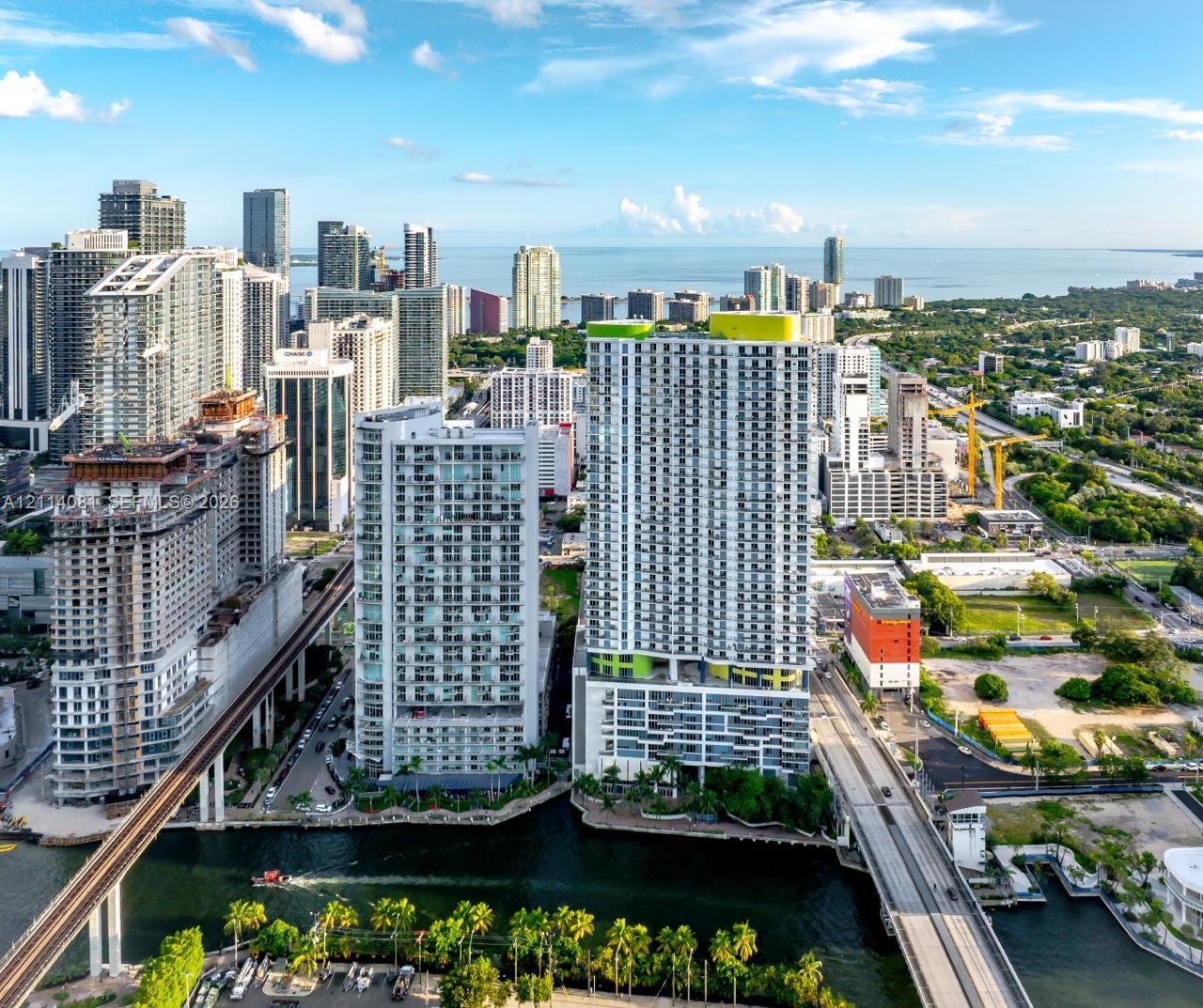 High-rise building featuring private balconies, floor-to-ceiling windows, and waterfront positioning within an urban landscape