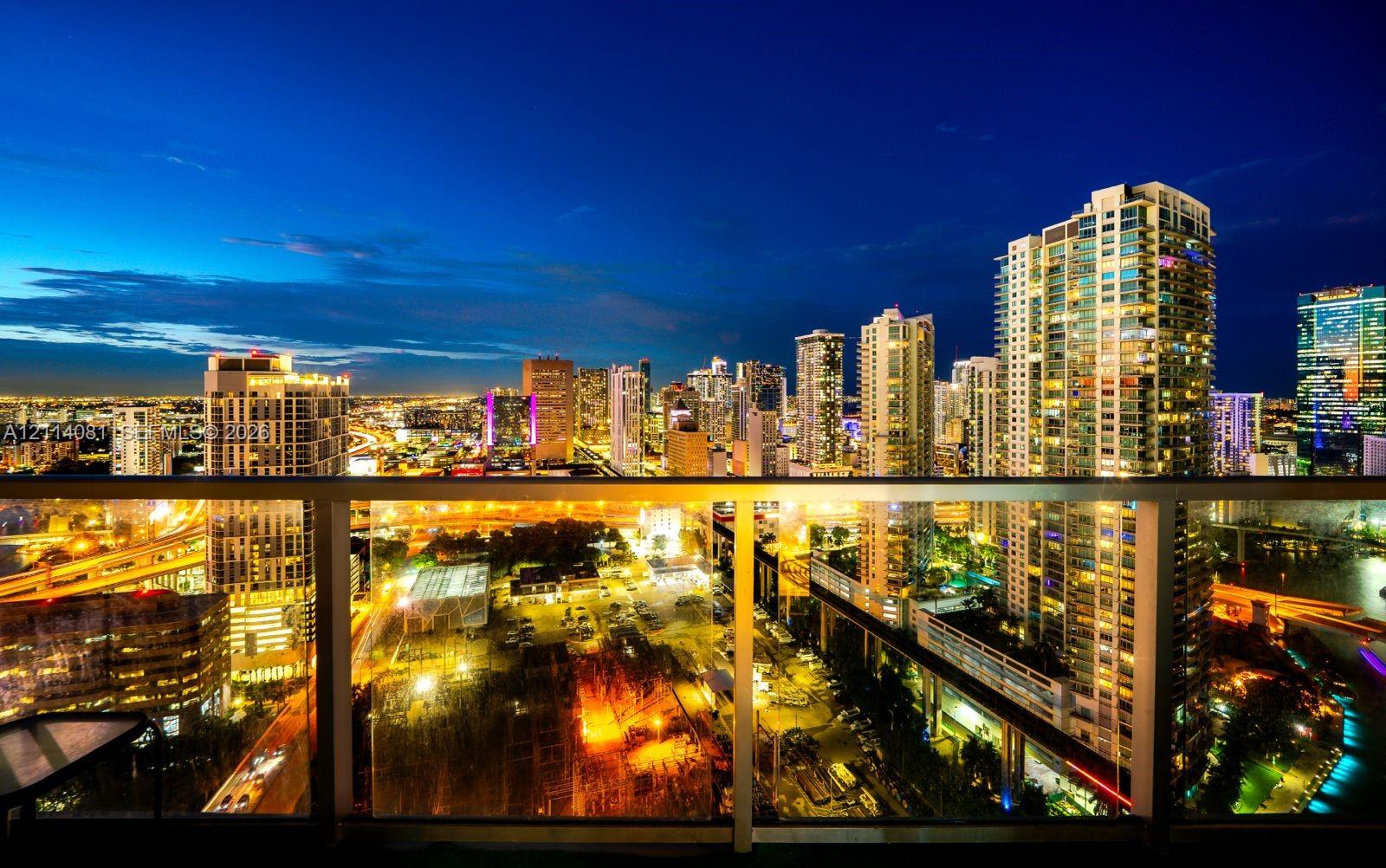 Private balcony featuring a glass panel railing and panoramic urban skyline scenery