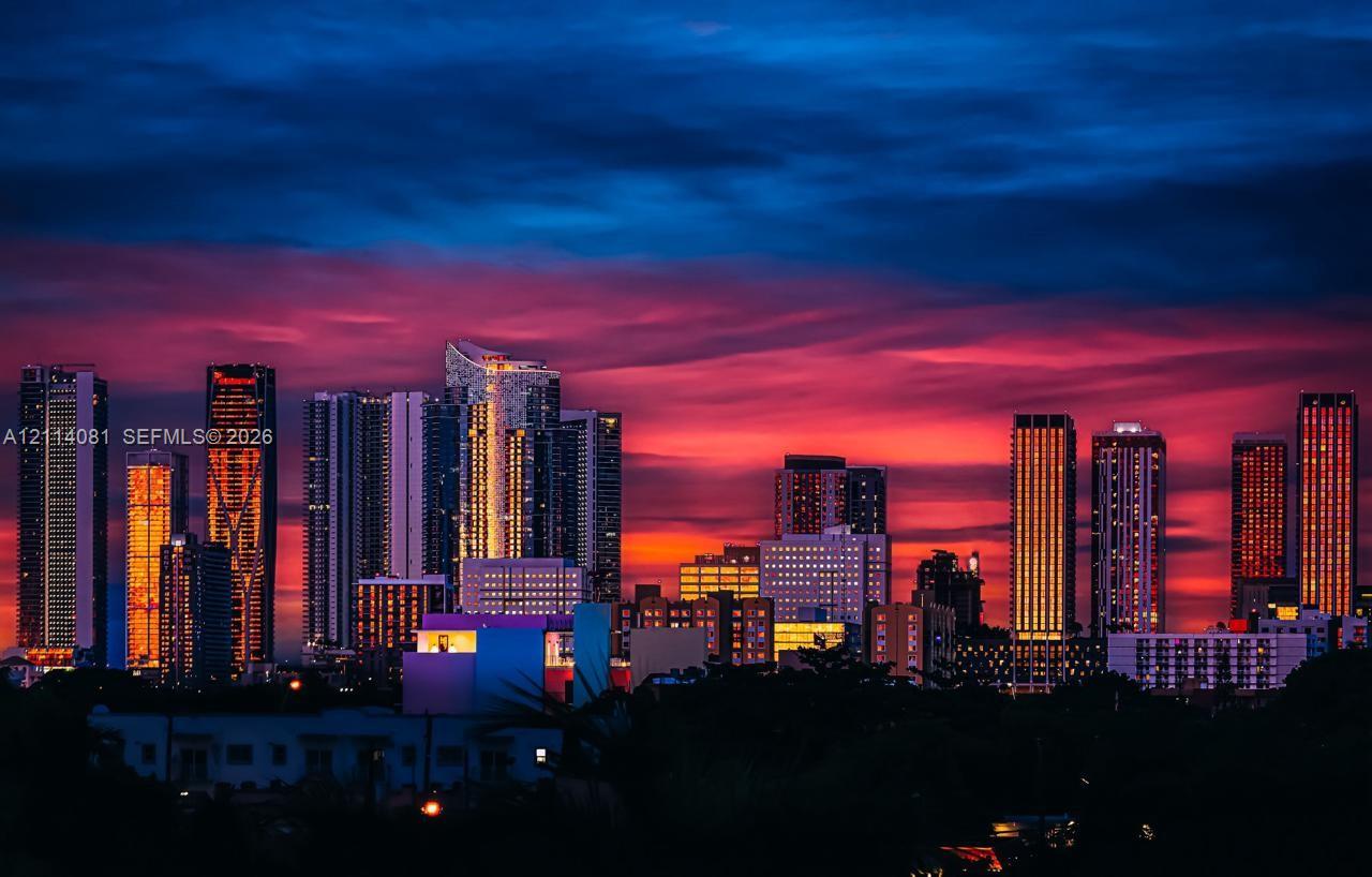 Panoramic cityscape featuring high-rise buildings and a vibrant sunset skyline