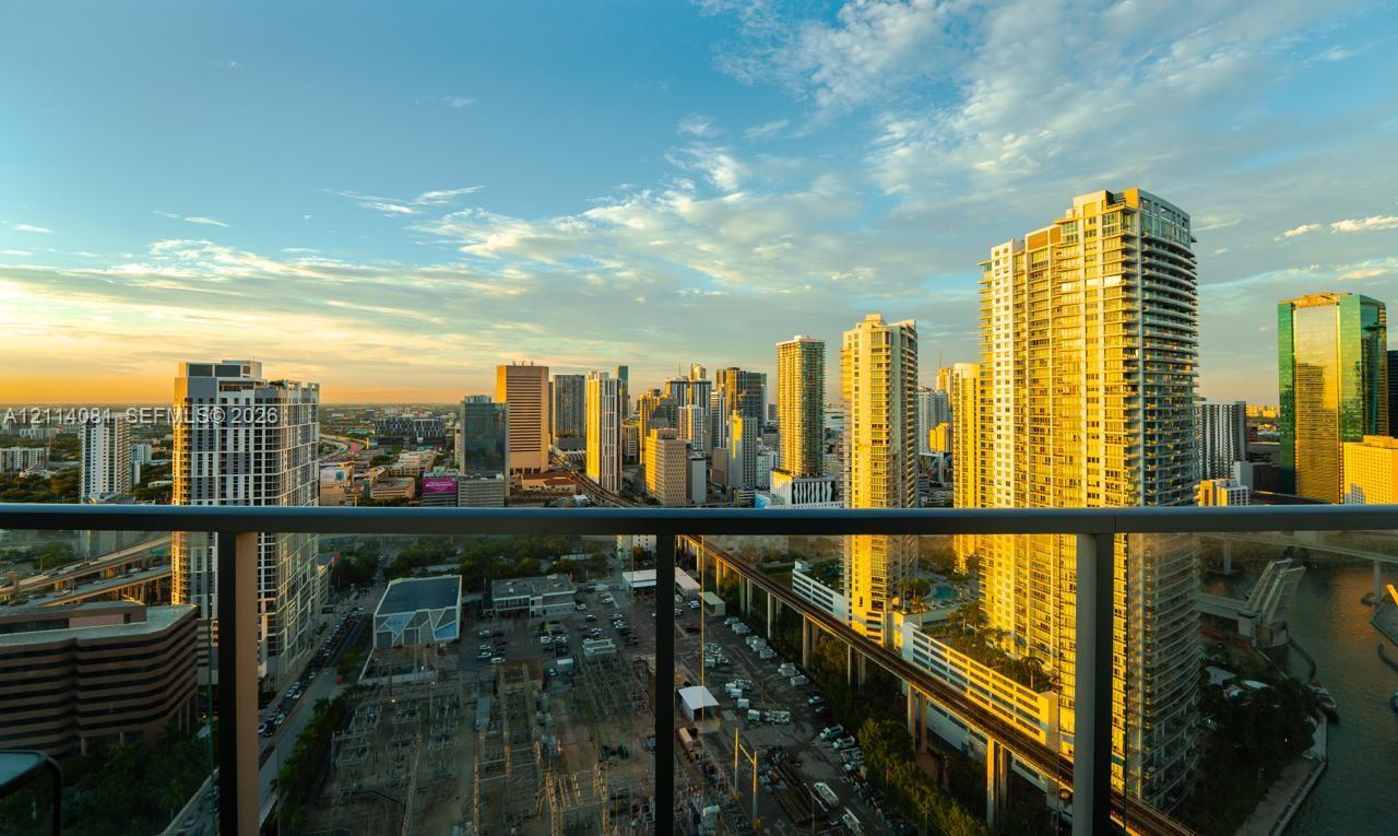 Elevated balcony featuring a matte black metal railing and expansive urban skyline scenery