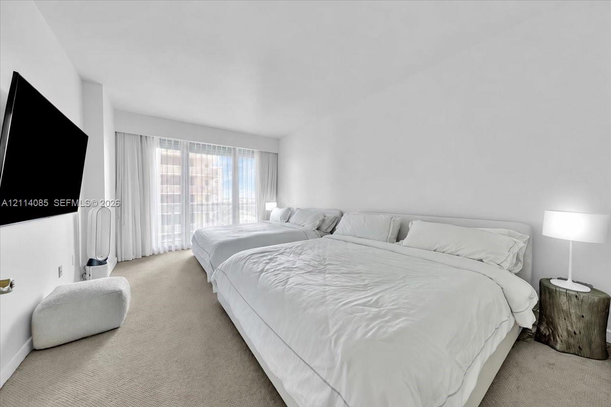 Wall-to-wall carpeting, floor-to-ceiling windows, and sheer drapery