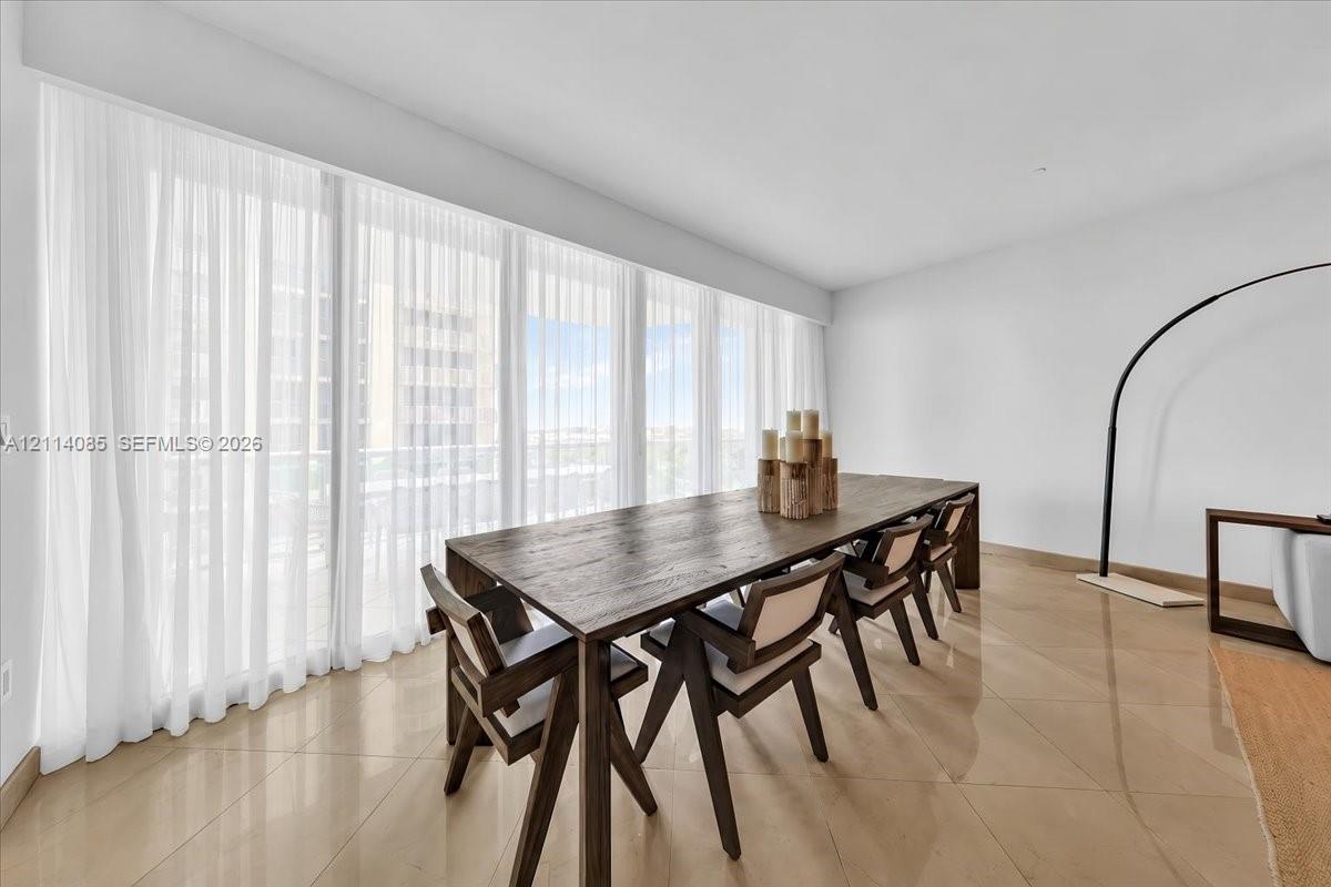 Floor-to-ceiling windows with expansive wall-to-wall treatment and polished stone-finish flooring