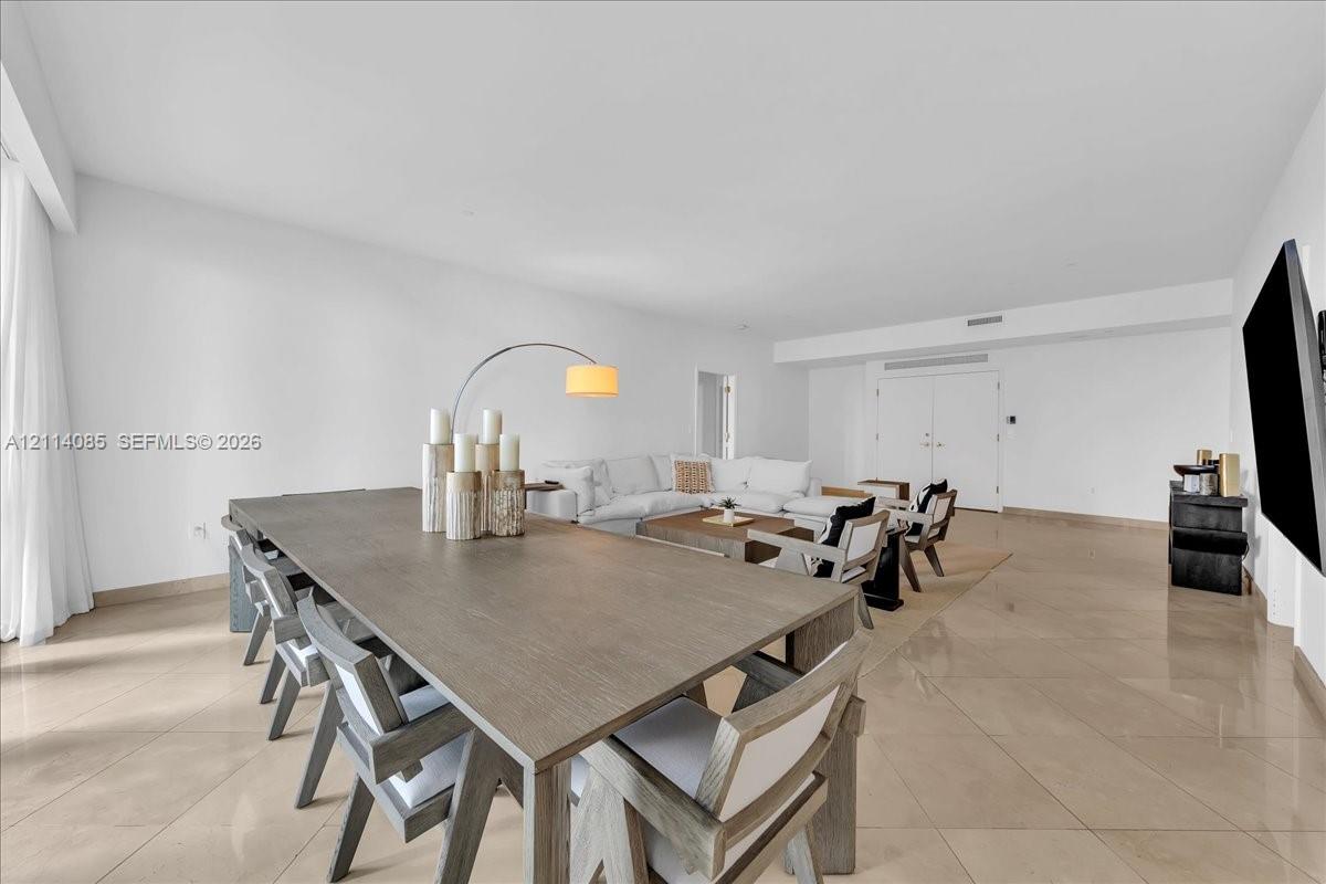 Open-concept interior featuring large-format tile flooring, smooth wall finishes, and recessed ceiling lighting