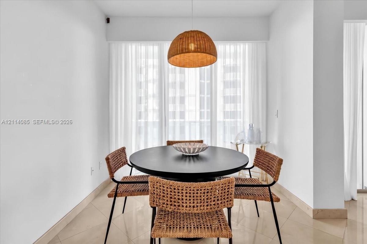 Woven dome pendant light, large-format tile flooring, and floor-to-ceiling sheer window treatments