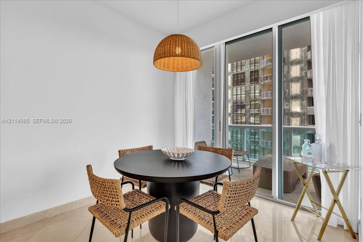 Floor-to-ceiling glass sliders, polished stone flooring, and a woven dome pendant light fixture