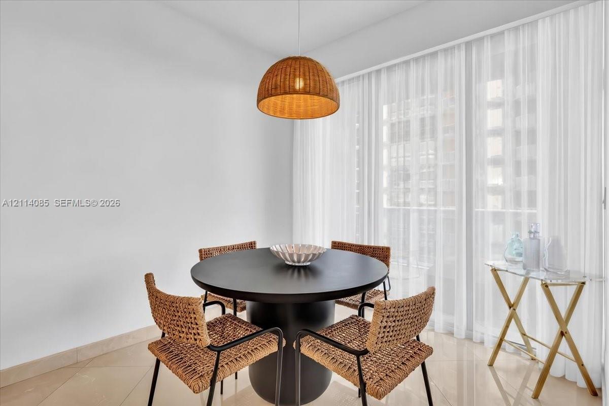 Woven dome pendant light, large-format tile flooring, and floor-to-ceiling sheer window treatments