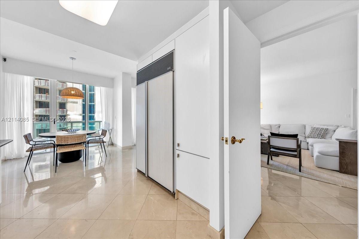 Panel-ready refrigerator, polished tile flooring, and floor-to-ceiling windows