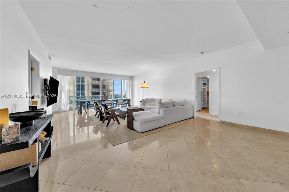 Open-concept living area with large-format tile flooring and expansive floor-to-ceiling windows