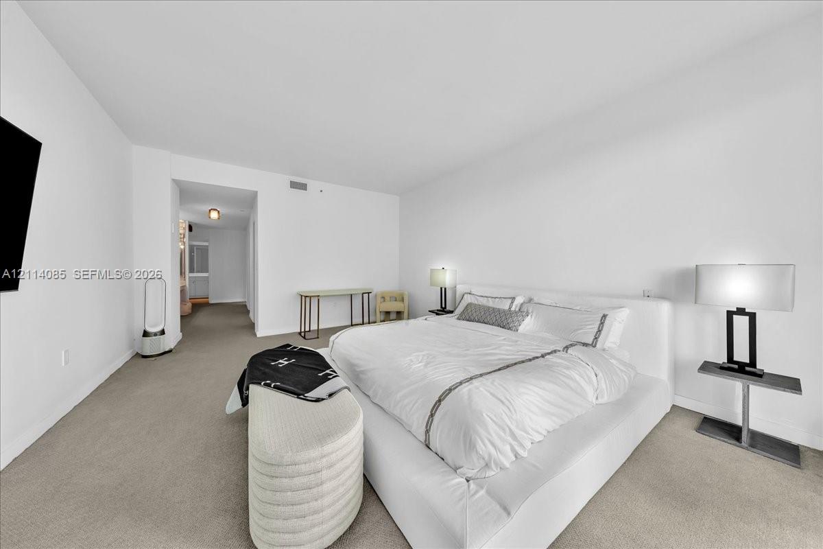 Neutral-toned wall-to-wall carpeting and clean, white-painted wall finishes